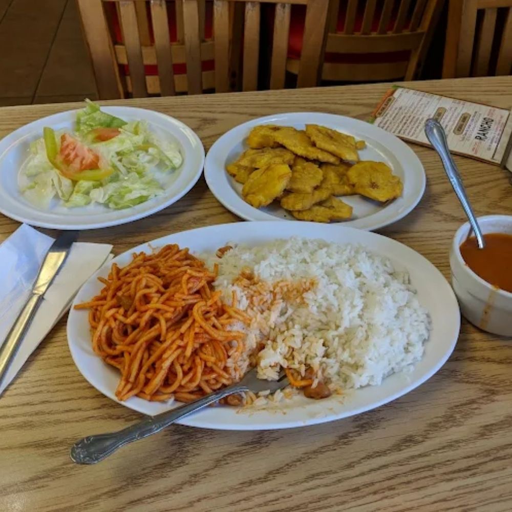 A plate with rice, salad and tostones